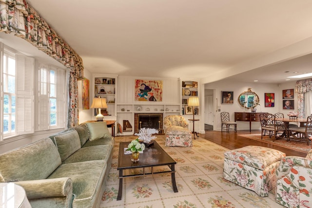 301 Margaret Blvd, Merrick, NY 11566 - living room featuring a tile fireplace, wood finished floors, and built in shelves
