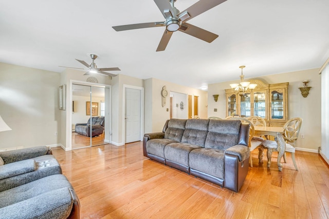 14015 159th St, Jamaica, NY 11434 - living room featuring a chandelier, light wood-style flooring, baseboards, ceiling fan, and healthy amount of natural light