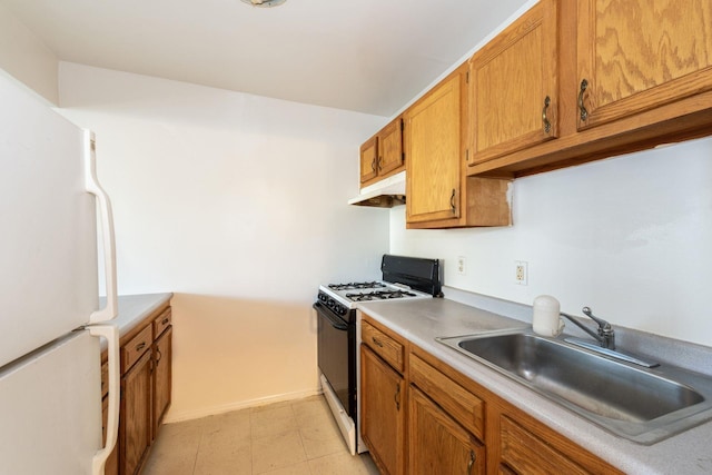 1830 Sterling Pl, Brooklyn, NY 11233 - kitchen with gas range, freestanding refrigerator, a sink, under cabinet range hood, and brown cabinets
