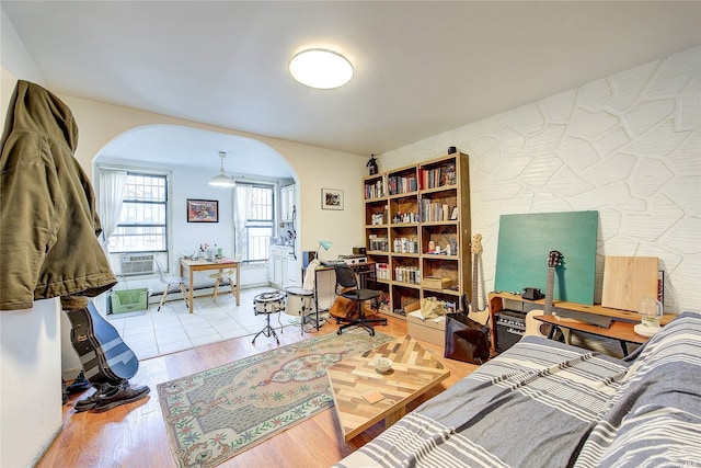 230 S 2nd St, Brooklyn, NY 11211 - bedroom with arched walkways, a desk, a baseboard radiator, and wood finished floors