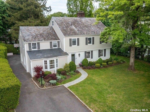 22 Homer Pl, Manhasset, NY 11030 - view of front facade with driveway, a chimney, a front lawn, and an attached garage