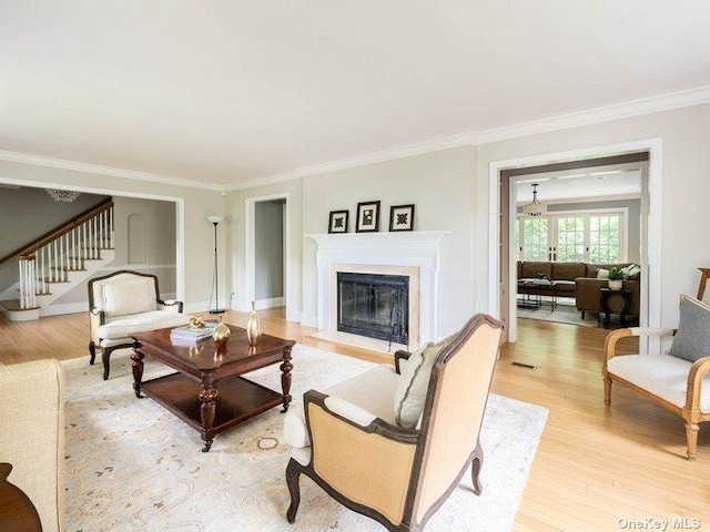 22 Homer Pl, Manhasset, NY 11030 - living area with light wood-type flooring, crown molding, stairs, a glass covered fireplace, and baseboards