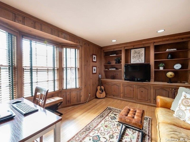 22 Homer Pl, Manhasset, NY 11030 - living area featuring light wood-type flooring, wooden walls, an office area, and ornamental molding