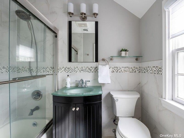22 Homer Pl, Manhasset, NY 11030 - full bathroom with vanity, combined bath / shower with glass door, tile walls, toilet, and vaulted ceiling