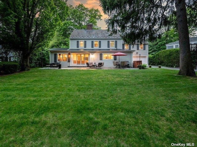 22 Homer Pl, Manhasset, NY 11030 - back of house with a lawn, a chimney, a patio, and a garage