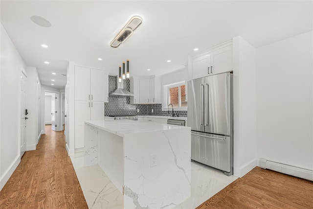 567 E 80th St, Brooklyn, NY 11236 - kitchen with appliances with stainless steel finishes, wall chimney range hood, white cabinetry, a center island, and light stone countertops