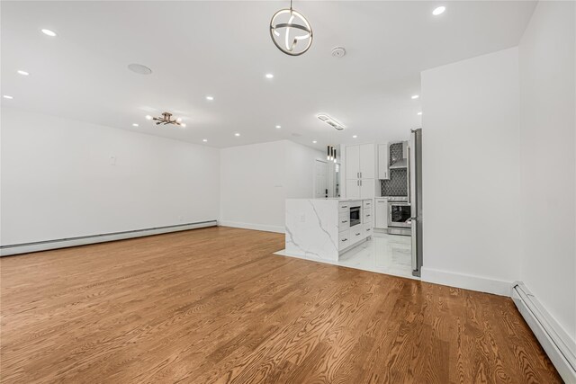 567 E 80th St, Brooklyn, NY 11236 - unfurnished living room featuring baseboard heating, recessed lighting, light wood-style floors, baseboards, and a baseboard radiator
