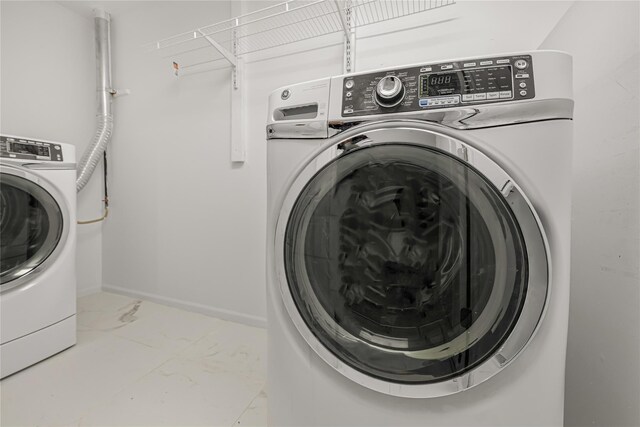 567 E 80th St, Brooklyn, NY 11236 - laundry area with washer / dryer, baseboards, and marble look tiles