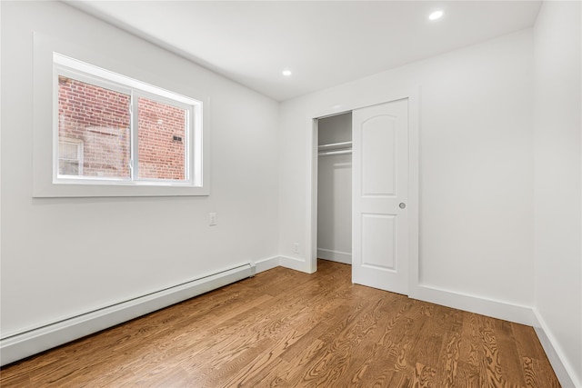 567 E 80th St, Brooklyn, NY 11236 - unfurnished bedroom featuring baseboard heating, wood finished floors, recessed lighting, baseboards, and a closet
