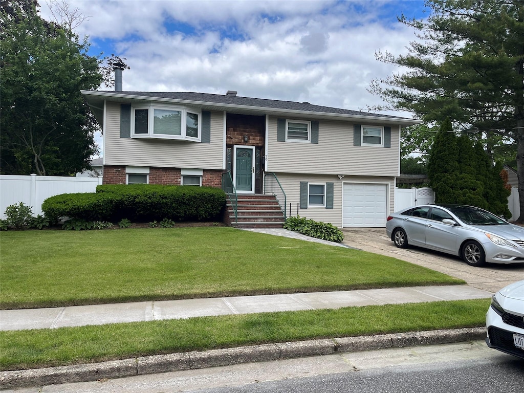 70 Pacific St, North Babylon, NY 11703 - bi-level home with a garage, concrete driveway, and a chimney