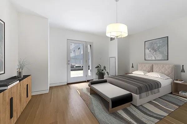 135 W 52nd St Unit 8D, New York Manhattan, NY 10019 - bedroom with light wood-style floors and access to exterior
