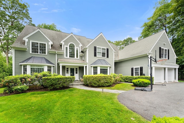 19 Rock Hill Ln, Scarsdale, NY 10583 - view of front of property with driveway, a garage, a front yard, and a standing seam roof