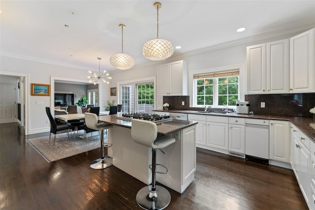 19 Rock Hill Ln, Scarsdale, NY 10583 - kitchen featuring stainless steel gas stovetop, a kitchen bar, white cabinetry, a chandelier, and decorative backsplash