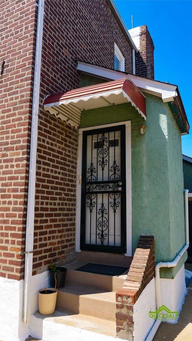 204-03 Murdock Ave, Saint Albans, NY 11412 - view of exterior entry featuring brick siding and a chimney