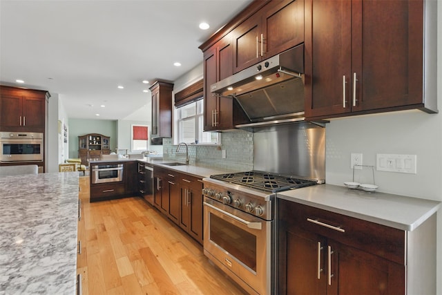 9 Constance Ave, Dobbs Ferry, NY 10522 - kitchen featuring stainless steel appliances, ventilation hood, a sink, light wood-style flooring, and tasteful backsplash
