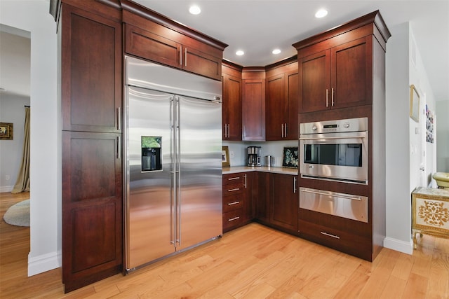 9 Constance Ave, Dobbs Ferry, NY 10522 - kitchen featuring stainless steel appliances, a warming drawer, light wood-style flooring, baseboards, and light countertops