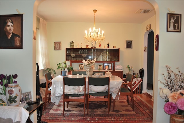 4026 208th St, Bayside, NY 11361 - dining space with arched walkways, a chandelier, and wood finished floors