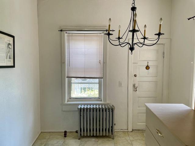 32-17 46th St, Astoria, NY 11103 - dining area with radiator heating unit, a chandelier, and light tile patterned floors