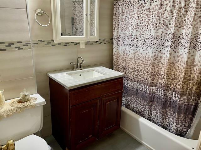 32-17 46th St, Astoria, NY 11103 - full bathroom featuring tile walls, vanity, toilet, and shower / bathtub combination with curtain