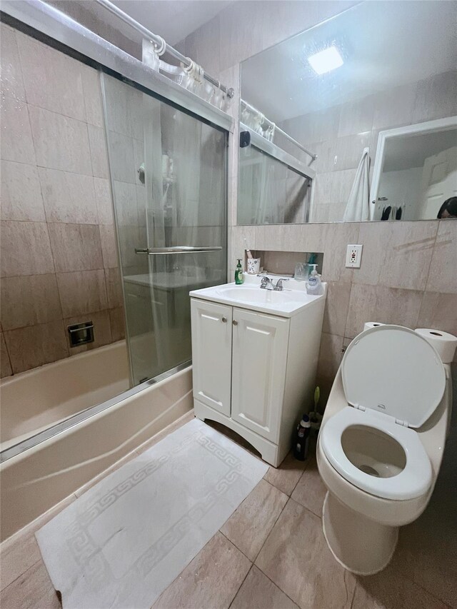 4231 Colden St Unit R6C, Flushing, NY 11355 - bathroom featuring enclosed tub / shower combo, tile patterned floors, vanity, toilet, and tile walls