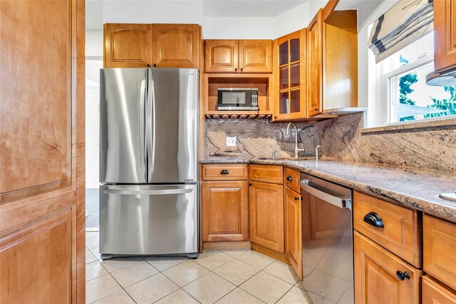 7931 211th St, Oakland Gardens, NY 11364 - kitchen featuring appliances with stainless steel finishes, light stone counters, light tile patterned floors, and backsplash