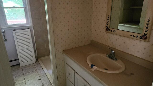48 Julie Dr, Hopewell Junction, NY 12533 - full bathroom with wallpapered walls, vanity, a baseboard radiator, tiled shower, and tile patterned flooring