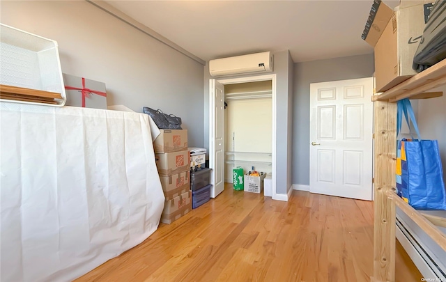 71-24 163rd St Unit 5A, Fresh Meadows, NY 11365 - bedroom with a wall mounted air conditioner, light wood-style flooring, and baseboards