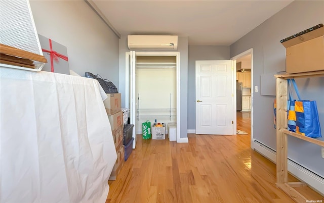 71-24 163rd St Unit 5A, Fresh Meadows, NY 11365 - bedroom with a wall mounted AC, light wood-style floors, freestanding refrigerator, and baseboard heating