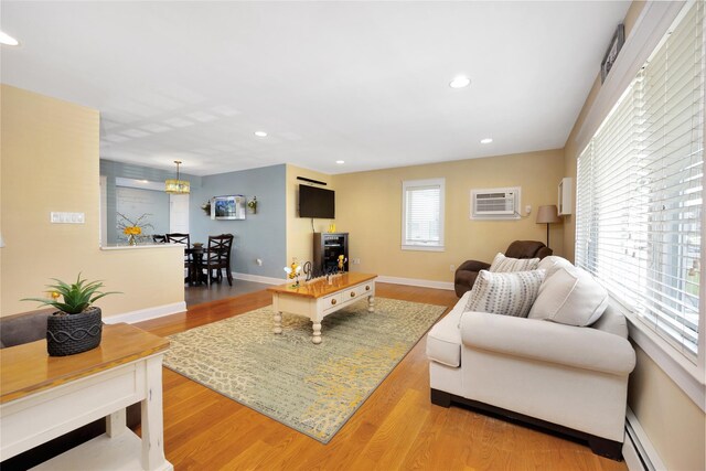 27 Armour St, Long Beach, NY 11561 - living room featuring a baseboard heating unit, a wall mounted air conditioner, wood finished floors, baseboards, and recessed lighting
