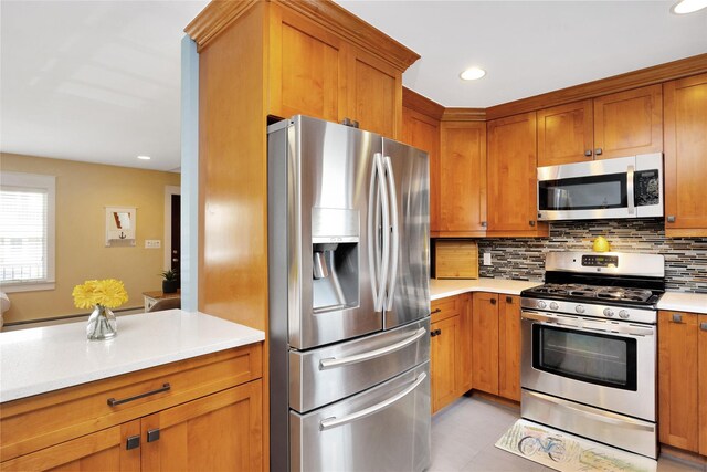 27 Armour St, Long Beach, NY 11561 - kitchen featuring appliances with stainless steel finishes, backsplash, light countertops, brown cabinetry, and recessed lighting