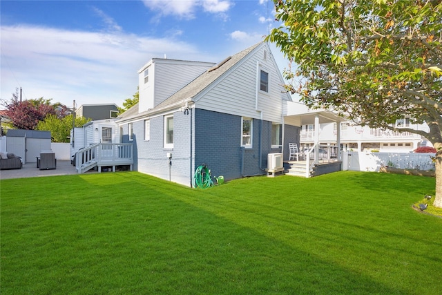 27 Armour St, Long Beach, NY 11561 - back of property with brick siding, central air condition unit, and a wooden deck