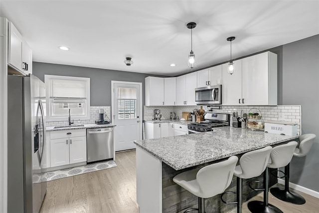 26 Richard Ave, Ronkonkoma, NY 11779 - kitchen featuring appliances with stainless steel finishes, a peninsula, white cabinetry, backsplash, and recessed lighting