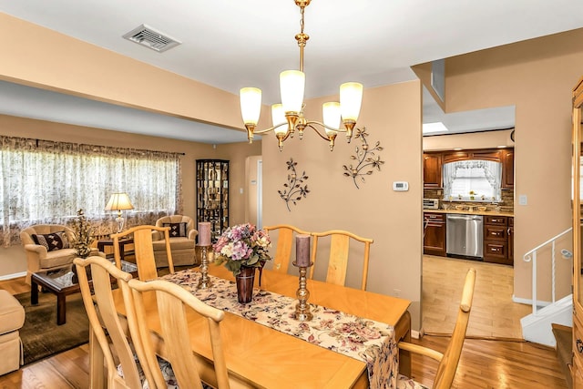 1197 Tulip Ave, Franklin Square, NY 11010 - dining space with light wood-style flooring, a chandelier, plenty of natural light, and stairway