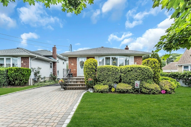 1197 Tulip Ave, Franklin Square, NY 11010 - bungalow-style home with brick siding, a front lawn, and a chimney