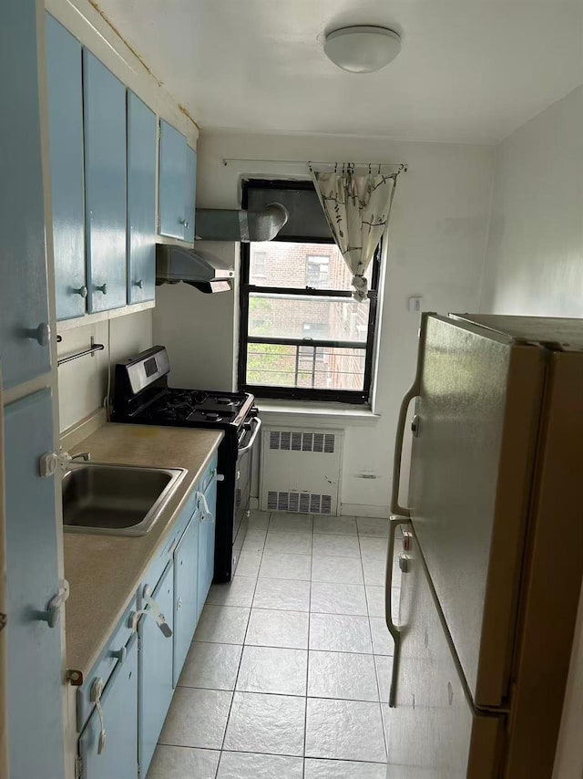 2625 141st St Unit 5A, Flushing, NY 11354 - kitchen with range with gas stovetop, blue cabinets, radiator, range hood, and freestanding refrigerator