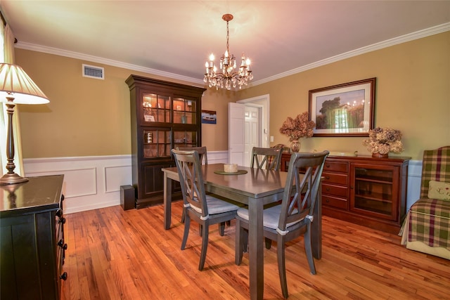12 Cordwood Path, Shoreham, NY 11786 - dining space featuring a chandelier, light wood-style floors, crown molding, and wainscoting