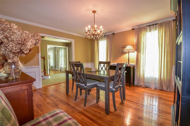 12 Cordwood Path, Shoreham, NY 11786 - dining area featuring a chandelier, a wainscoted wall, light wood finished floors, and crown molding