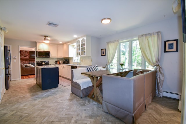 12 Cordwood Path, Shoreham, NY 11786 - kitchen with stainless steel microwave, freestanding refrigerator, black range with electric stovetop, a center island, and light countertops