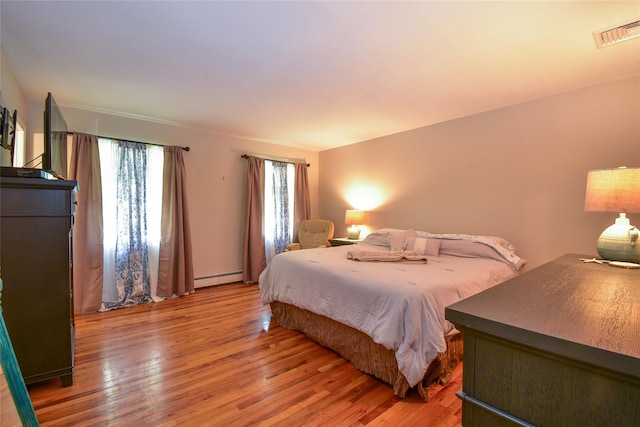 12 Cordwood Path, Shoreham, NY 11786 - bedroom with light wood finished floors and a baseboard radiator