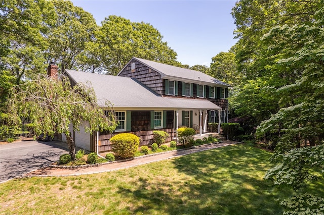 12 Cordwood Path, Shoreham, NY 11786 - view of front of home with a chimney, driveway, a front lawn, a shingled roof, and a garage