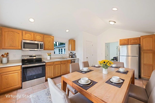 138 Greene Ave, Port Jefferson Station, NY 11776 - kitchen featuring stainless steel appliances, a sink, vaulted ceiling, light countertops, and light tile patterned floors