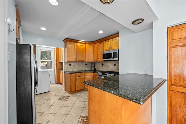 11148 128th St, South Ozone Park, NY 11420 - kitchen featuring appliances with stainless steel finishes, a sink, tasteful backsplash, light tile patterned flooring, and a peninsula