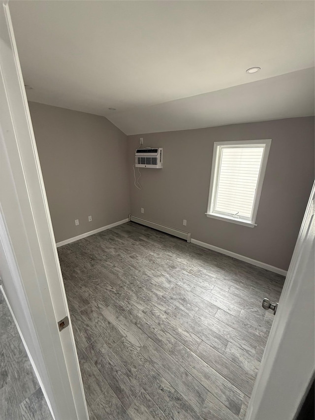 10917 124th St, South Ozone Park, NY 11420 - empty room with a baseboard radiator, wood finished floors, baseboards, vaulted ceiling, and a wall mounted air conditioner