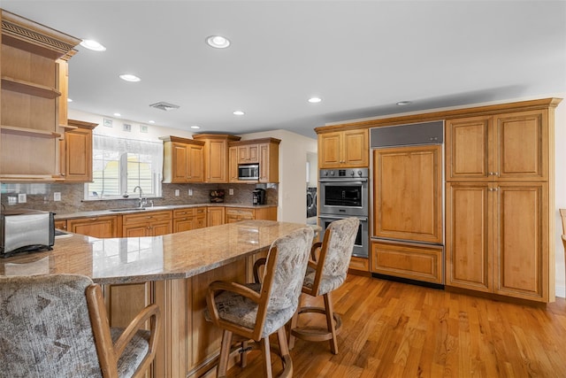 16 Hidden View Dr, Newburgh, NY 12550 - kitchen featuring stainless steel appliances, open shelves, light stone counters, light wood-type flooring, and a peninsula