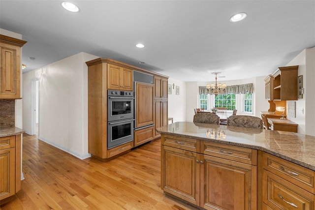 16 Hidden View Dr, Newburgh, NY 12550 - kitchen featuring stainless steel double oven, a chandelier, light wood-type flooring, brown cabinetry, and recessed lighting