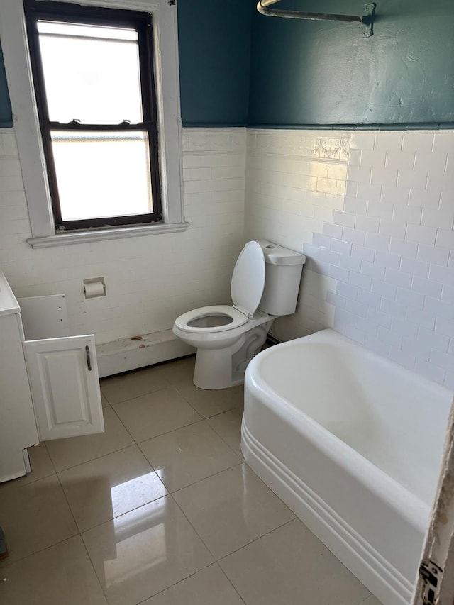 142 Cottage Ave, Mount Vernon, NY 10550 - bathroom with a bath, toilet, tile walls, tile patterned flooring, and a wainscoted wall