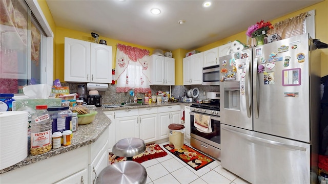 10920 116th St, South Ozone Park, NY 11420 - kitchen with stainless steel appliances, light tile patterned flooring, decorative backsplash, white cabinetry, and recessed lighting