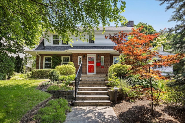 225 Fisher Ave, White Plains, NY 10606 - view of front facade featuring a chimney, brick siding, and a front yard