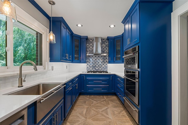 225 Fisher Ave, White Plains, NY 10606 - kitchen with blue cabinets, stovetop, wall chimney range hood, recessed lighting, and light countertops