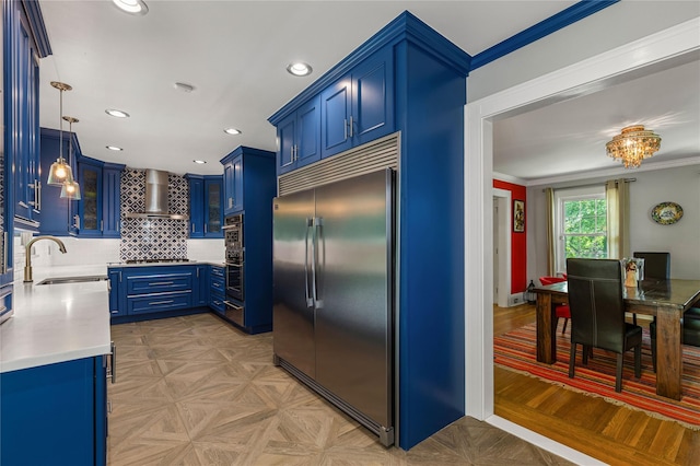 225 Fisher Ave, White Plains, NY 10606 - kitchen with built in refrigerator, wall chimney exhaust hood, blue cabinets, light countertops, and backsplash